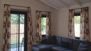 A room with a dark blue sofa, wooden flooring, and a ceiling with exposed beams. - Botanika Hotel Sapanca (Sapanca)
