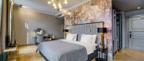 Un dormitorio moderno con una cama grande, una araña, un escritorio y un mural en la pared.