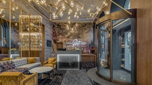 Un moderno vestíbulo de hotel con mostrador de recepción, zona de estar y una gran estantería.
