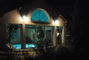 Una casa con piscina, ventanas amplias y techo curvo.