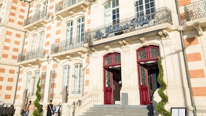 A historic building with ornate architecture, a grand entrance, and a flag.