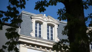 Un edificio de estilo arquitectónico clásico, con una ventana destacada que presenta molduras decorativas y una fachada simétrica.