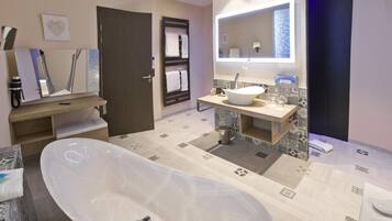 A modern bathroom with a freestanding bathtub, a vanity with a sink, and a large mirror.