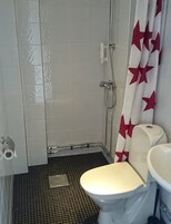 Un baño con ducha, inodoro y lavamanos.