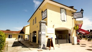 A yellow building with a sign for "Rêverbère la cuisine et la boutique." - Le Réverbère - La Cuisinerie - L'Hôtellerie (Vic-en-Bigorre)