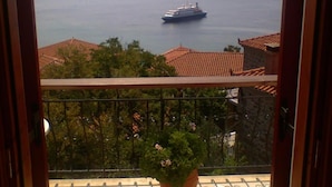 Un balcon avec vue sur la mer et les montagnes lointaines.