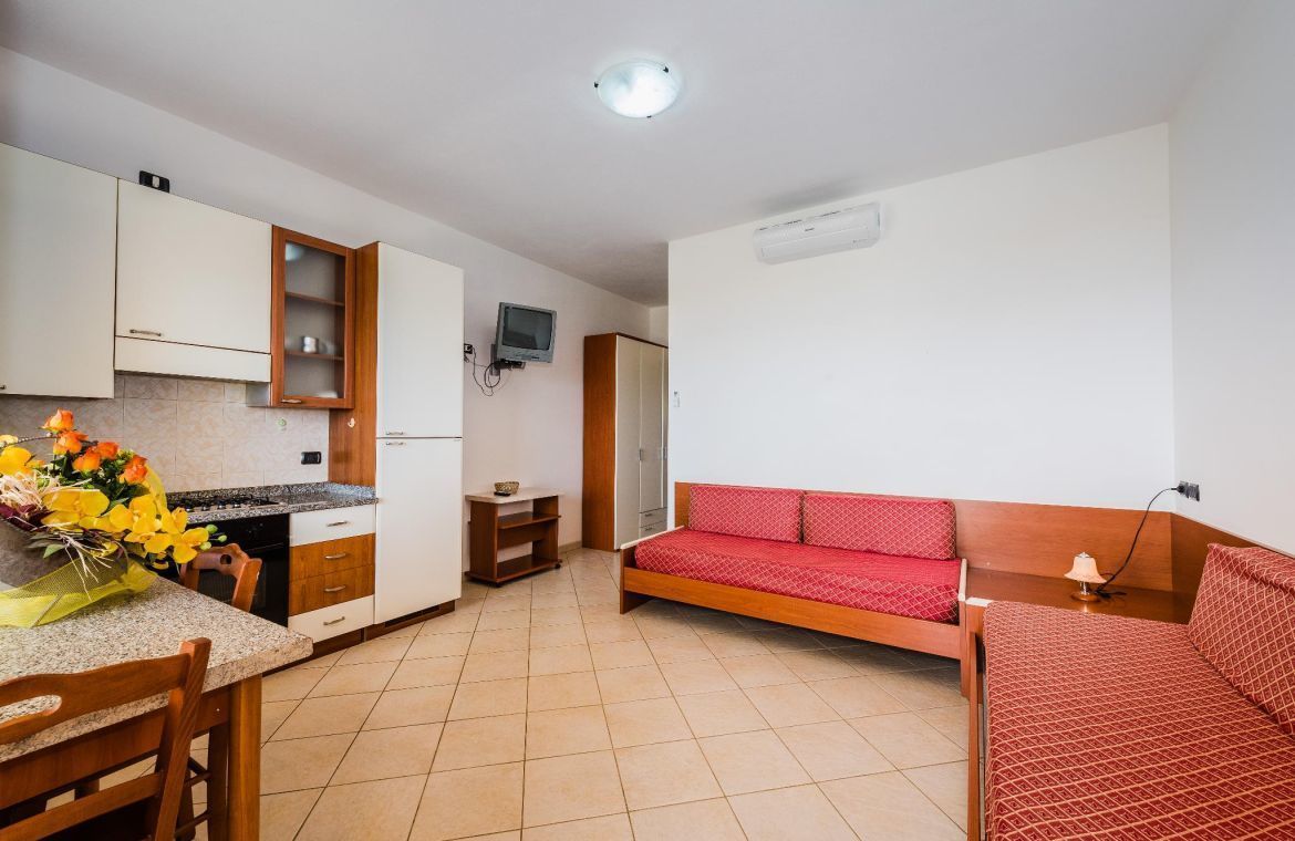 A compact living space with a kitchenette, a sofa, and a dining area.