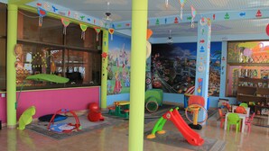 Un espace de jeux pour enfants, décoré de manière attrayante, avec des meubles colorés et un toboggan.