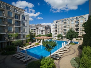 A multi-story residential building with balconies, a swimming pool, and lounge areas. - Apart-hotel Dawn Park (Sunny Beach)