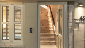 Entrada de un apartamento moderno con una escalera que lleva a un balcón.