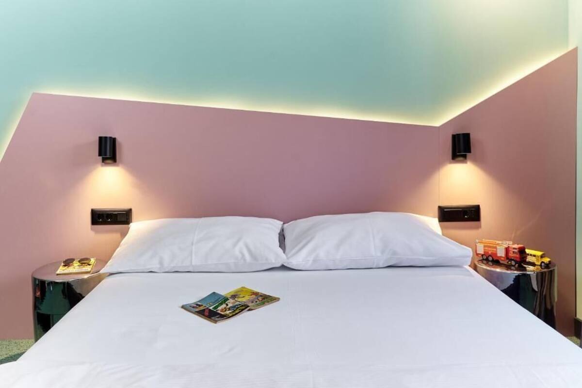 Ein Hotelzimmer mit einem Bett, zwei Nachttischen und Wandlampen.