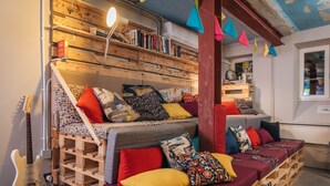 Una habitación acogedora con una cama, una guitarra y una estantería llena de libros.