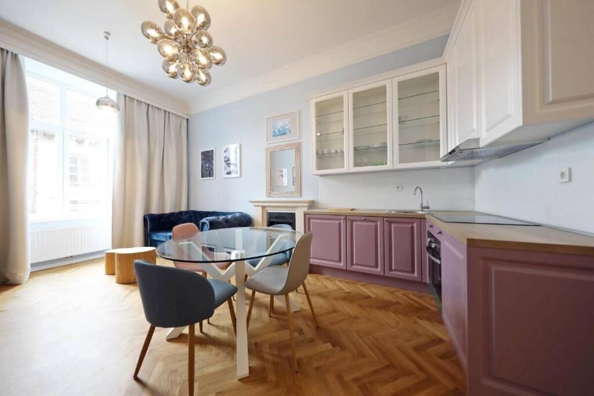 Eine moderne Küche mit Esstisch, Stühlen und einem Einbauofen.
