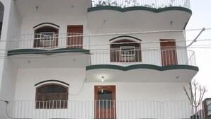 A multi-story building with balconies and a sign reading "Rainbow Guest House." - Rainbow Guest House (Gaya)