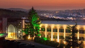 A hotel with a modern design, featuring a large arched entrance and a row of windows along the side. - Park Hotel RAYA Garden (Veliko Tarnovo)