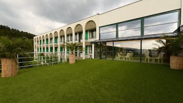 Een modern gebouw met een plat dak, grote ramen en een gazon.