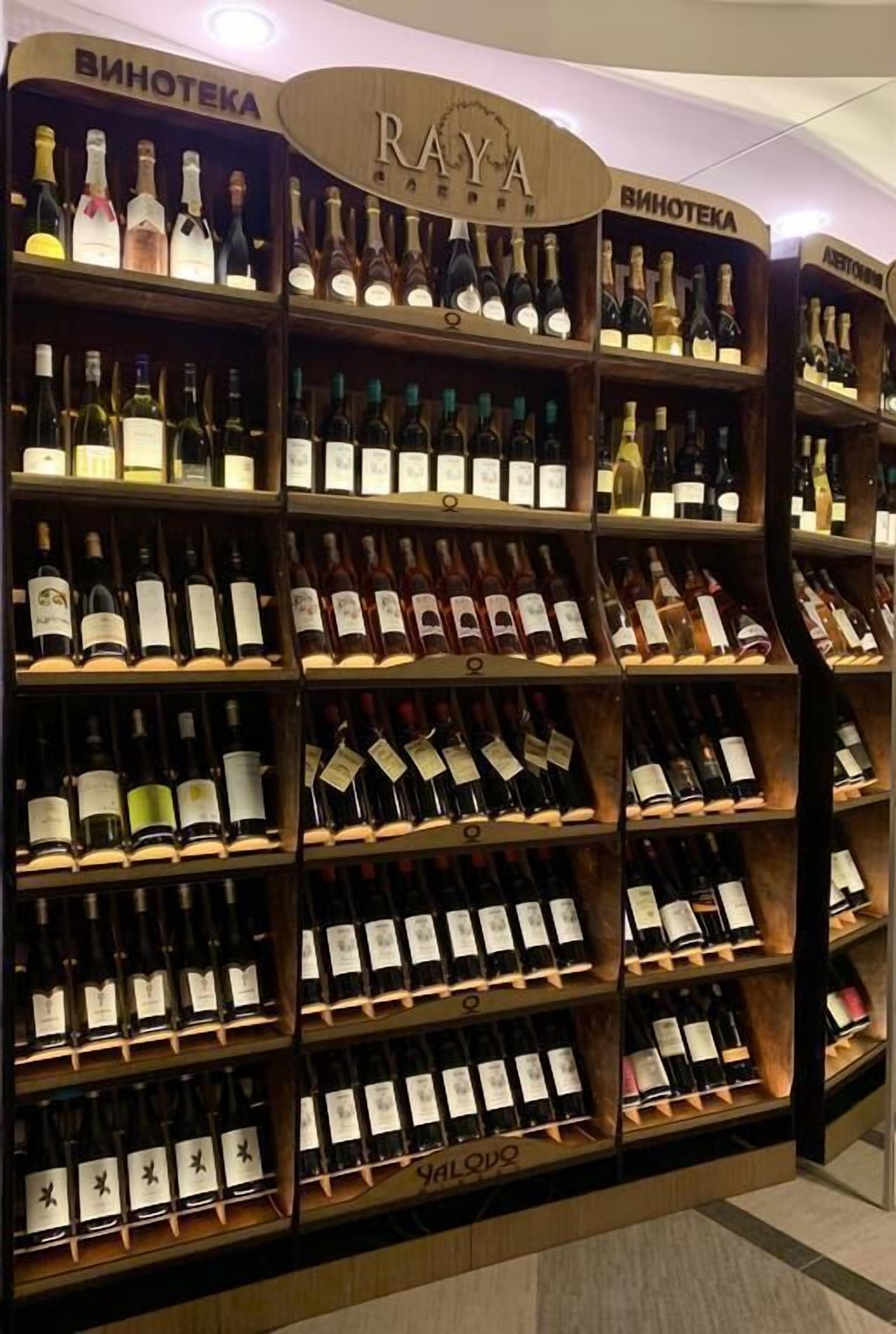 Una exhibición de vinos con varias estanterías, cada una con diferentes botellas.