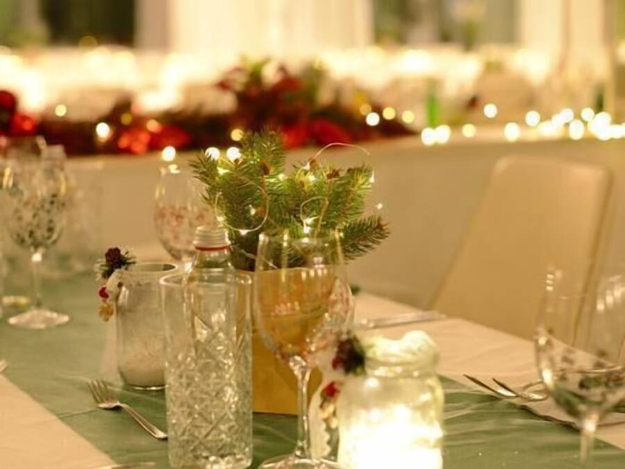 Ein gedeckter Tisch mit Geschirr, Kerzen und einer Weihnachtsdeko.