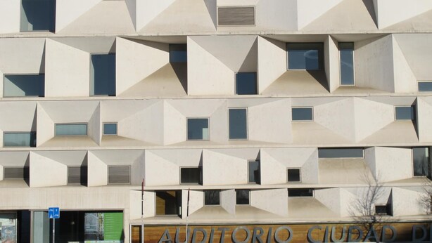 Un edificio moderno con fachada geométrica y varias ventanas.