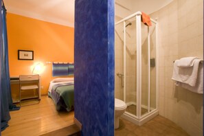A bathroom with a shower, toilet, and bed. - Blanca by gaiarooms (León)