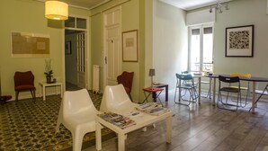 Un salón amplio con mesa de comedor, varias sillas y un sofá blanco.
