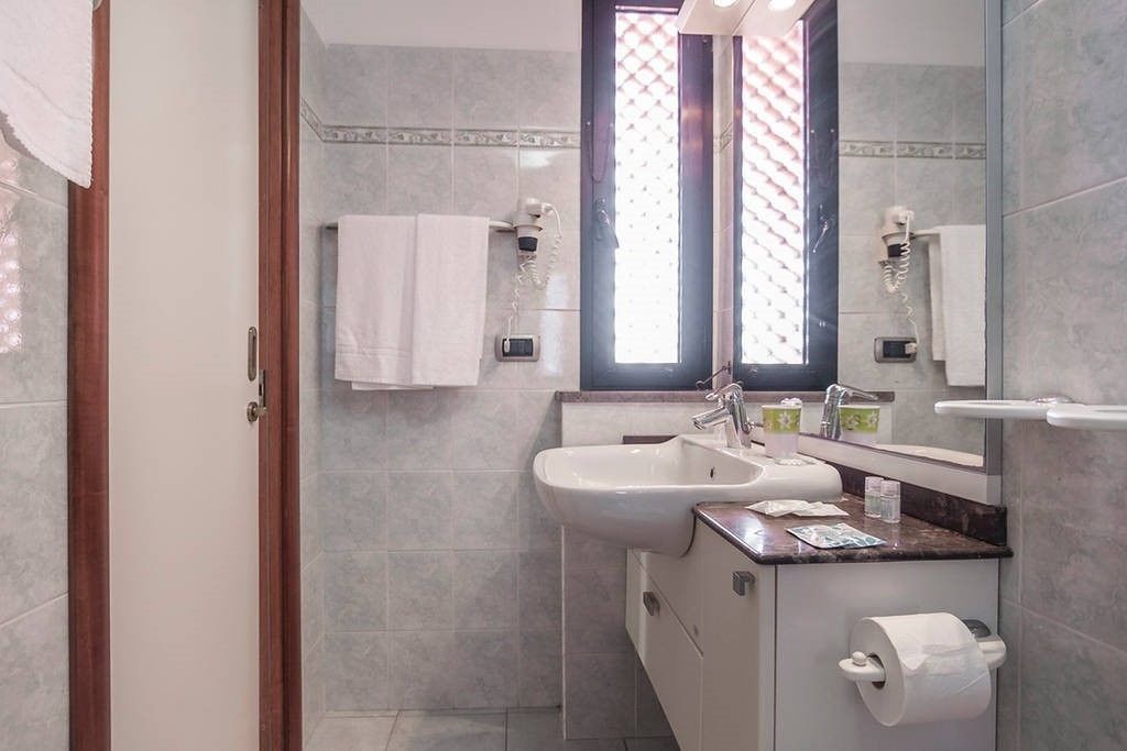 Une salle de bain moderne avec un lavabo, un miroir et un porte-serviettes.