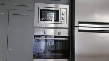 Una cocina con microondas y horno integrados, electrodomésticos de acero inoxidable y un diseño moderno.