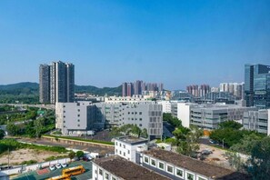 A high-rise building complex with multiple floors, surrounded by other buildings and greenery.