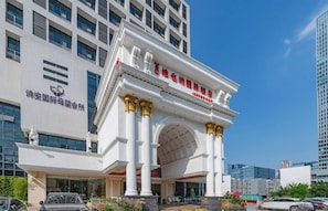 A modern building with a classical entrance featuring columns and a large archway. - Vienna Int Hotel Shenzhen Tian'an Digital City (Shenzhen)