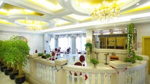 A hotel lobby with a reception desk, seating area, and a chandelier. - Vienna International Hotel (Shanghai)