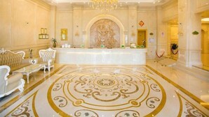 A luxurious lobby with a grand chandelier, ornate wall relief, and a patterned floor. - Vienna International Hotel (Shanghai)