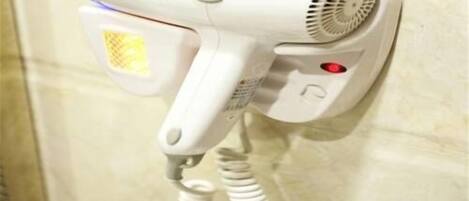 Un casc d'eixugar cabells fixat a la paret amb un cable.