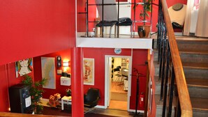 Un interior de varios niveles con una escalera, un escritorio con una computadora y una silla.