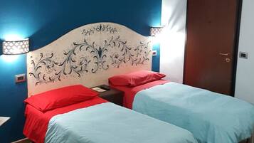 Una habitación con cama, dos mesitas de noche y una puerta.
