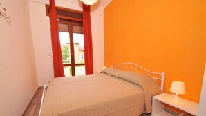 A bedroom with a bed, a nightstand, and a window with curtains. - Amami Viaggi - Casa Venere (Capaccio-Paestum)
