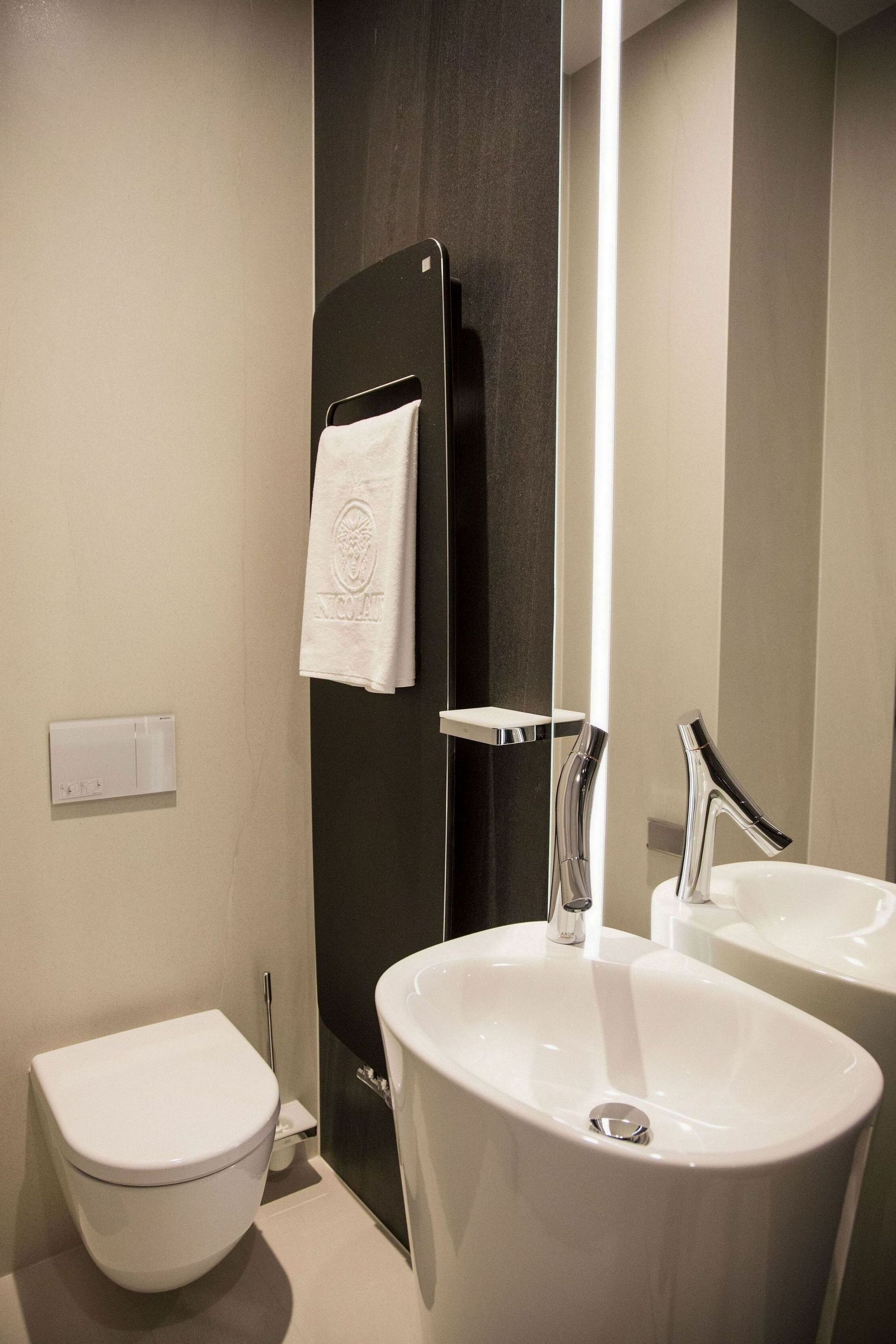 A modern bathroom with a toilet, a sink, and a mirror.