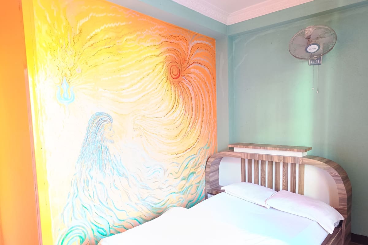 Un dormitorio con una cama, una pared con un diseño ondulante, un ventilador y un interruptor de luz.