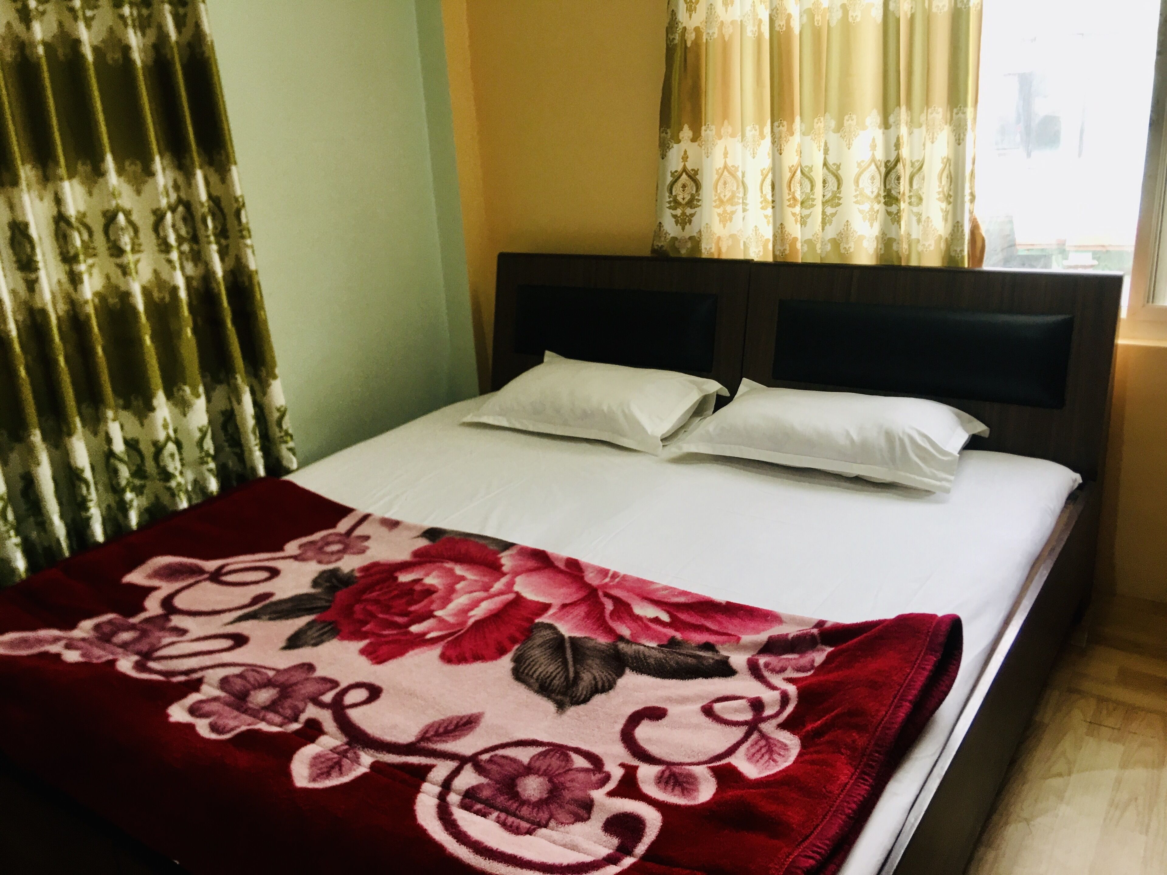 Una cama con colcha estampada, dos almohadas y cabecero.