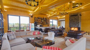 Amplia sala de estar con chimenea, ventanas grandes y detalles de madera.