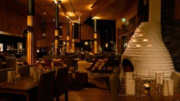 Un restaurante con interiores de madera, varias mesas y sillas.