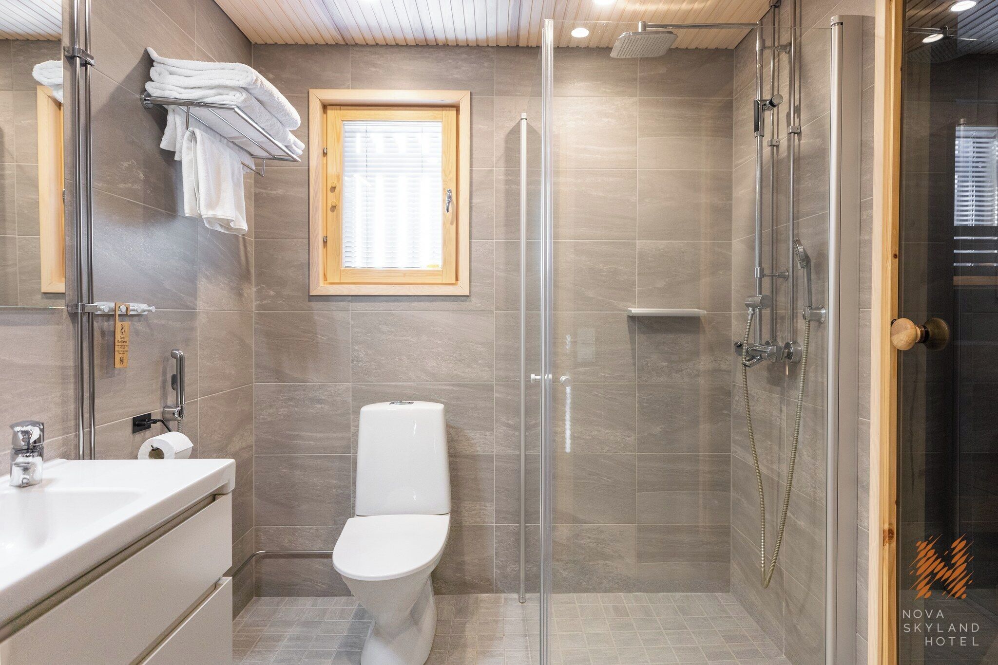Un baño moderno con ducha de vidrio, inodoro y lavabo.