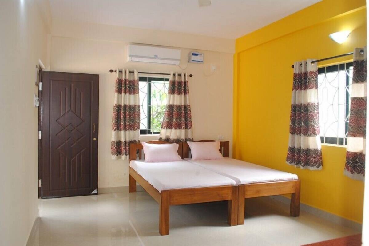 A room with a wooden bed, a brown door, and yellow walls.