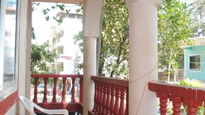 Un balcón con mantel a cuadros, una decoración con una estrella roja y vistas de los edificios y árboles circundantes.