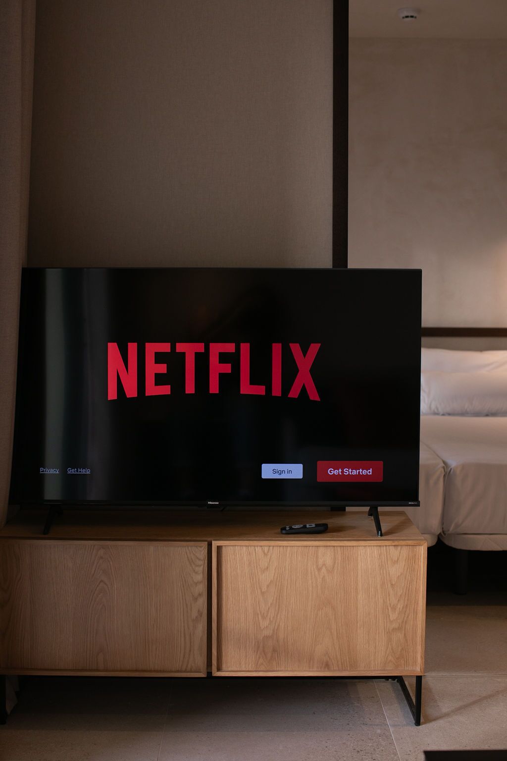 Ein Fernseher auf einem Holzboden, mit dem Netflix-Logo und Optionen zum Einloggen oder Starten.