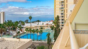 A resort with a swimming pool, palm trees, and a view of the ocean. - Apartamentos Playazul (Arona)
