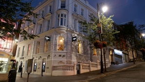 A historic building with a corner entrance, large windows, and a well-lit facade. - Shipquay Boutique Hotel (Londonderry)