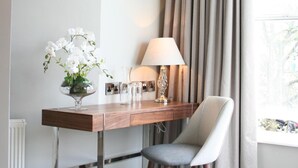 A hotel room with a desk, chair, lamp, and a window with curtains. - Shipquay Boutique Hotel (Londonderry)