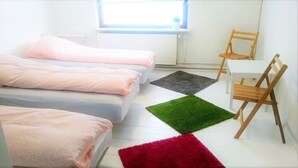 A bedroom with two beds, a small table, and a chair. - Pasescia Bed and Breakfast (Kolind)