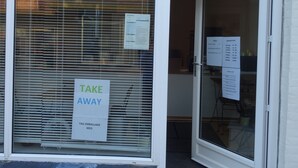 A cafe entrance with a 'TAKE AWAY' sign, a menu board, and a window with blinds. - Pasescia Bed and Breakfast (Kolind)