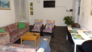 A living room with a sofa, two armchairs, a coffee table, and a TV. - Pasescia Bed and Breakfast (Kolind)